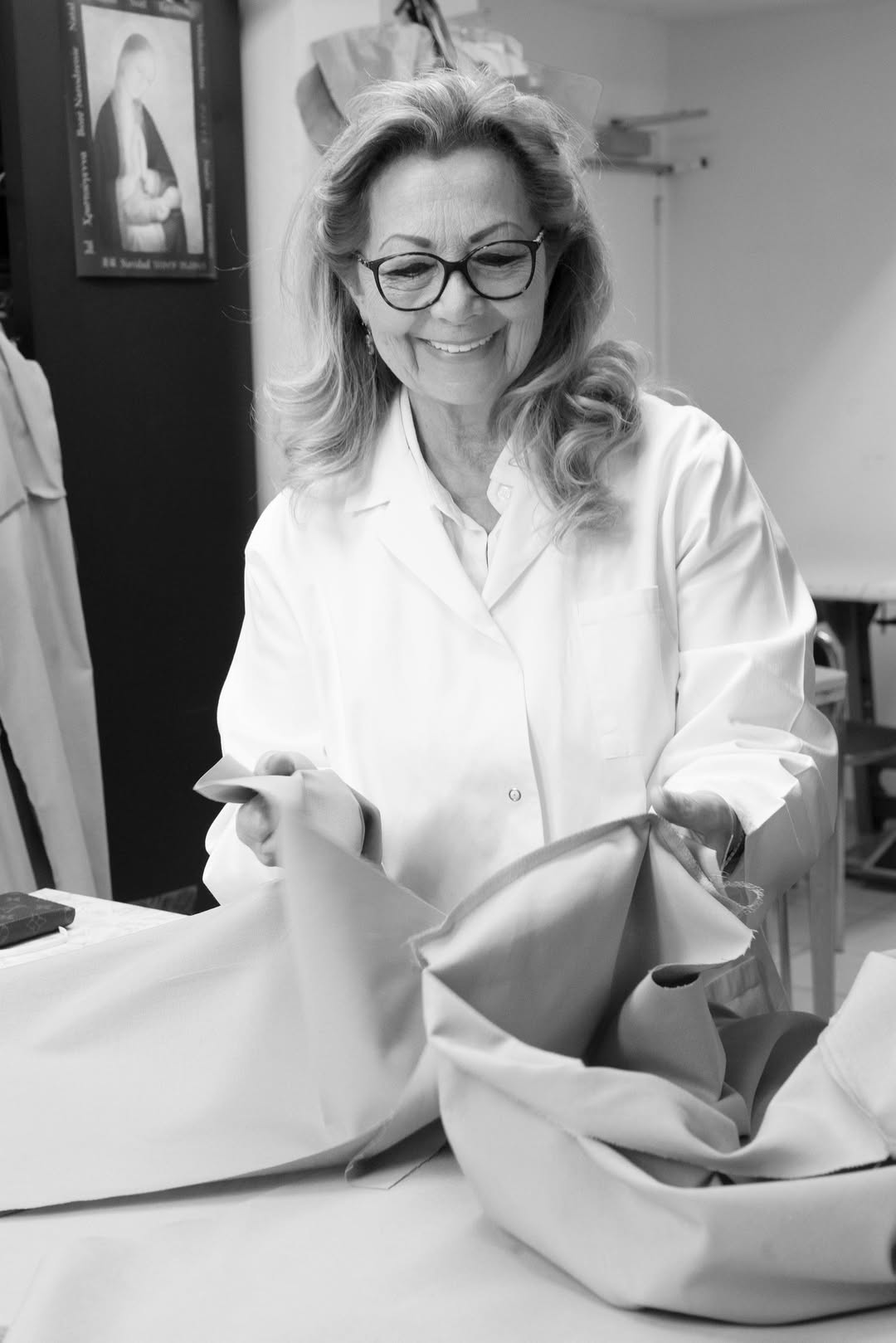 Madame Fuchs-Lejeune in the atelier, white coat, fabric in her hands